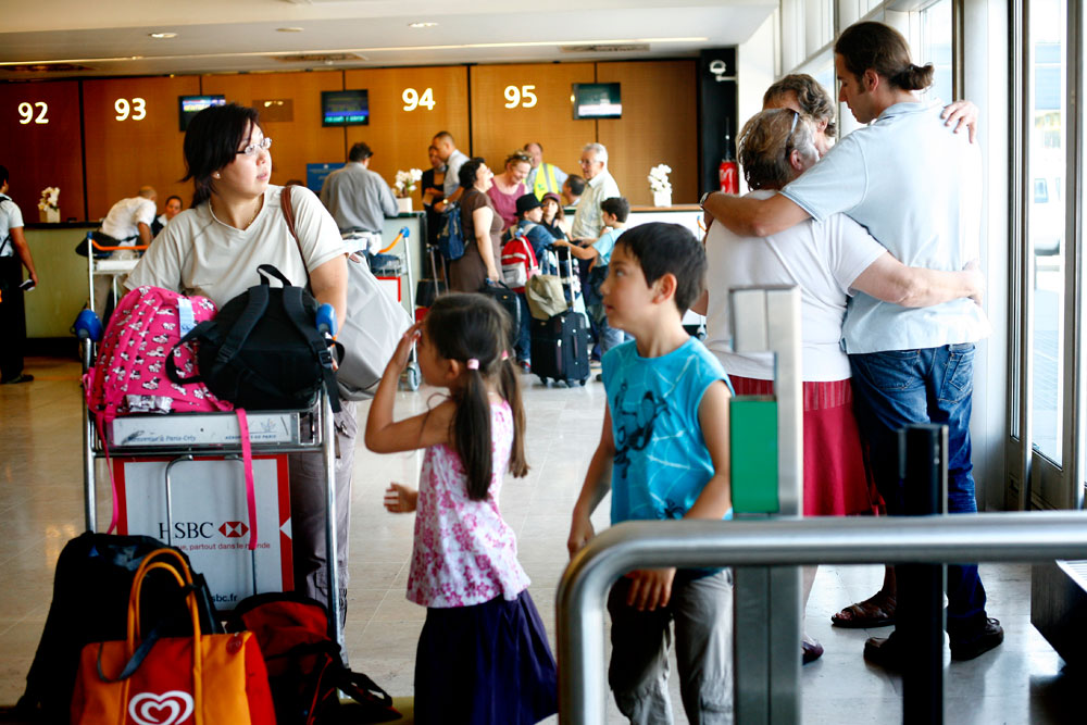 Le jour du départ, toute la famille - parents, grands parents, frères, soeurs et amis - se retrouvent à l'aéroport.
La mère de Yoann a préparé des sandwichs au saucisson et du raisin pour les enfants. La mère de Chhor-Huy des pains au poulet et à la coriandre et des litchis.