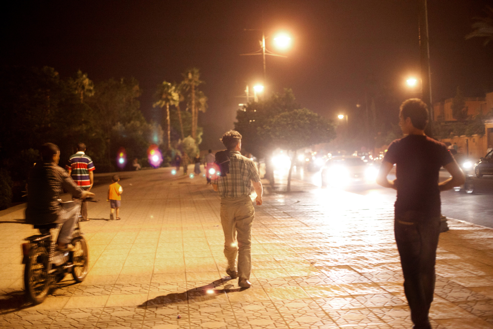 Marrakech, quartier de la Koutoubia, près de la Place Djema el Fna. 
Un touriste va à la rencontre de jeunes hommes, dans un parc.
