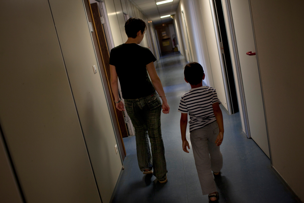 Carinne accompagne un tout jeune mineur dans la salle d'audition. 
