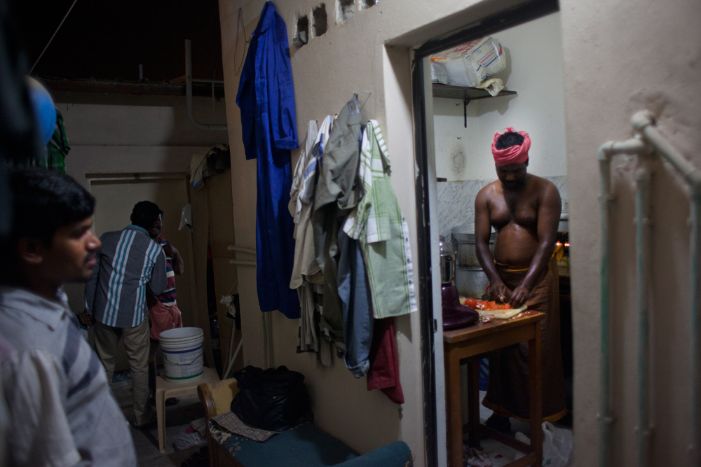 Camp Al Kharayej, à la périphérie de Doha. Un ouvrier fait la cuisine pour les autres habitants de sa chambre.