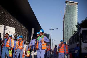 Les bus affrÃ©tÃ©s par les compagnies de construction dÃ©posent les ouvriers devant les chantiers du Centre de Doha, dans le quartier de la Corniche.
