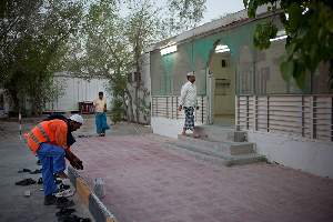 Camp Al Nakhla. Retour des ouvriers Ã  la tombÃ©e du jour pour l'heure de la priÃ¨re Ã  la mosquÃ©e.