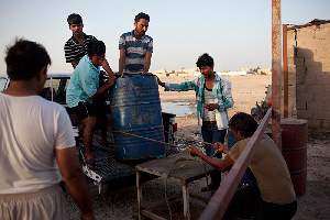 Le Camp Al Wakra, au milieu du désert n'a ni eau courante ni eau potable. Les ouvriers déchargent des barils d'eau, le soir, à la fin de leur journée de travail.